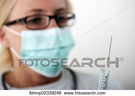 Stock Photograph - Doctor holding a syringe. Fotosearch