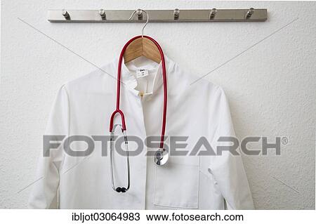 "Doctor's coat hanging on a coat hanger on a coat rack, with a stethoscope" View Large Photo Image Stock Image - "Doctor's coat hanging on a coat hanger on a coat rack, with a stethoscope". Fotosearch