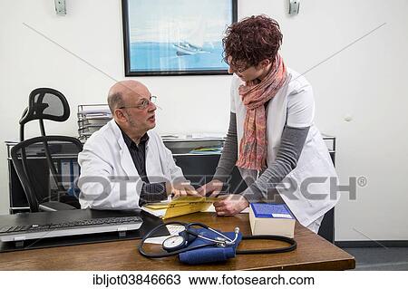 "Doctor's office, doctor's assistant and doctor reviewing a patient's records together, Germany, Europe" View Large Photo Image Stock Image - "Doctor's office, doctor's assistant and doctor reviewing a patient's records together, Germany, Europe". Fotosearch