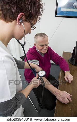 "Doctor's office, older patient gets his blood pressure taken by a doctor's assistant, Germany, Europe" View Large Photo Image Stock Photo - "Doctor's office, older patient gets his blood pressure taken by a doctor's assistant, Germany, Europe". Fotosearch