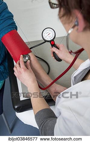 Stock Photo - "Doctor's office, patient gets her blood pressure taken by a doctor's assistant, Germany, Europe". Fotosearch