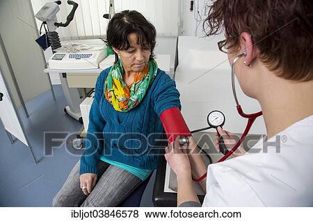 Stock Photo - "Doctor's office, patient gets her blood pressure taken by a doctor's assistant, Germany, Europe". Fotosearch