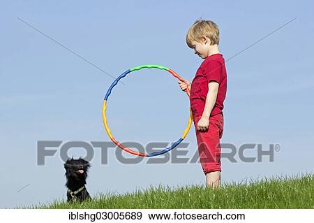 "Dog training, boy encouraging a dog to jump through a hoop, Wilhelmsburg, Hamburg, Hamburg, Germany, Europe" View Large Photo Image Stock Photo - "Dog training, boy encouraging a dog to jump through a hoop, Wilhelmsburg, Hamburg, Hamburg, Germany, Europe". Fotosearch