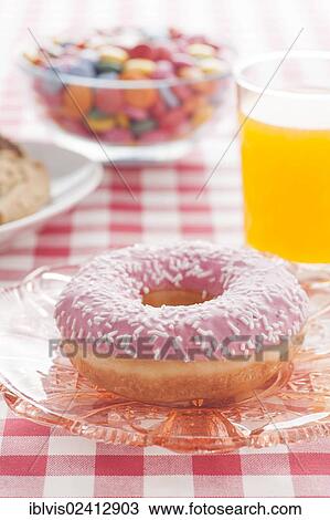 Stock Image - Donut with sprinkles and a glass of orange soda. Fotosearch