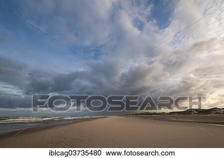 Stock Image - "Dramatic cloud formation with rain showers over a North Sea beach, Henne Strand, Jutland, Denmark, Europe". Fotosearch