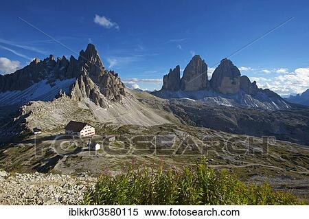Stock Photography - "Dreizinnenhuette or Three Peaks Alpine hut and chapel in front of Paternkofel Mountain and the north face of the Three Peaks, Sextner Dolomiten, South Tyrol province, Trentino-Alto Adige, Italy, Europe". Fotosearch