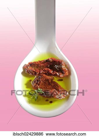 Dried tomatoes in olive oil on a white spoon View Large Photo Image Stock Photograph - Dried tomatoes in olive oil on a white spoon. Fotosearch