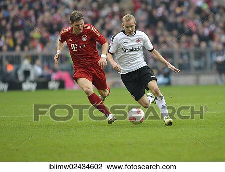 Stock Image - "Duel between Bastian SCHWEINSTEIGER, FC Bayern Munich, left, and Sebastian Rode, Eintracht Frankfurt, right, Allianz Arena, Munich, Bavaria, Germany, Europe". Fotosearch