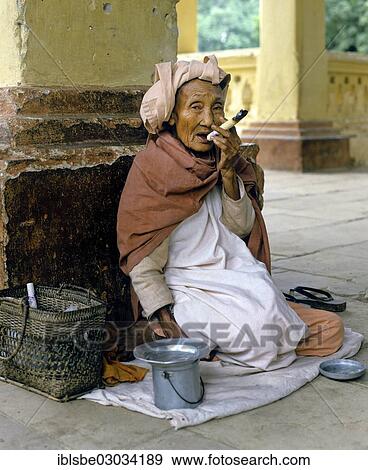 "Elderly Burmese woman smoking a Cheerot cigar and wearing a headscarf, beggar, Mingun, Mandalay, Sagaing-Division, Myanmar, Burma, Asia" View Large Photo Image Stock Photo - "Elderly Burmese woman smoking a Cheerot cigar and wearing a headscarf, beggar, Mingun, Mandalay, Sagaing-Division, Myanmar, Burma, Asia". Fotosearch