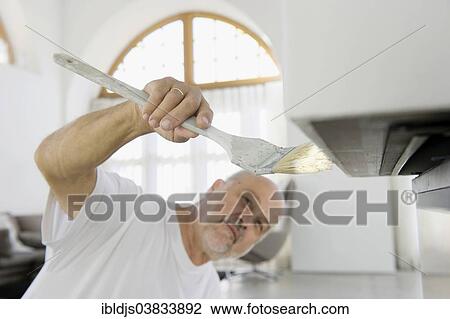 Elderly craftsman painting a surface View Large Photo Image Stock Image - Elderly craftsman painting a surface. Fotosearch