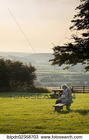 "Elderly gentleman sat on bench in country park, Buriton, Hampshire, England, United Kingdom, Europe" View Large Photo Image Stock Image - "Elderly gentleman sat on bench in country park, Buriton, Hampshire, England, United Kingdom, Europe". Fotosearch