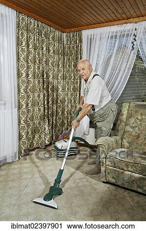 Elderly man cleaning his house with a vacuum cleaner View Large Photo Image Stock Image - Elderly man cleaning his house with a vacuum cleaner. Fotosearch