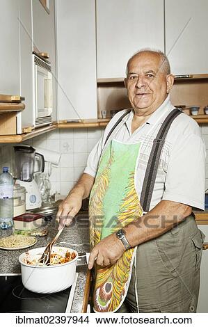 Elderly man cooking in the kitchen View Large Photo Image Picture - Elderly man cooking in the kitchen. Fotosearch