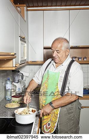 Elderly man cooking in the kitchen View Large Photo Image Stock Photography - Elderly man cooking in the kitchen. Fotosearch