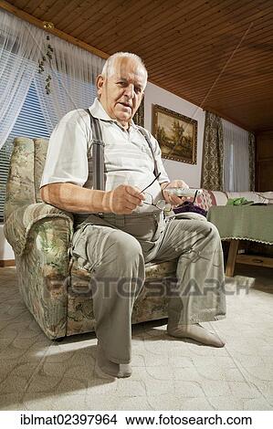 Elderly man holding a remote control View Large Photo Image Picture - Elderly man holding a remote control. Fotosearch