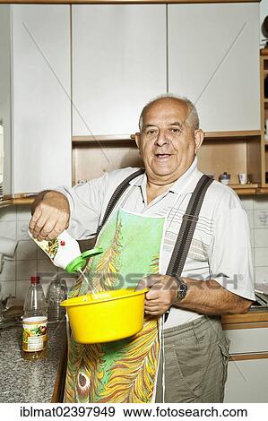Elderly man holding a salad bowl in a kitchen View Large Photo Image Stock Photo - Elderly man holding a salad bowl in a kitchen. Fotosearch