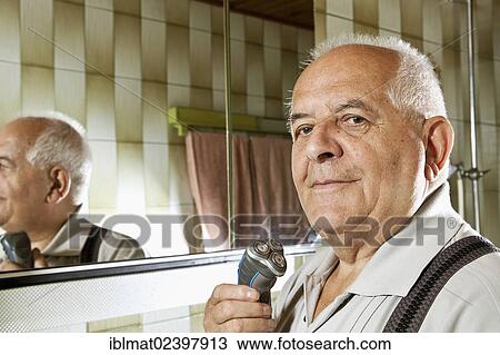 Elderly man holding an electric shaver View Large Photo Image Stock Image - Elderly man holding an electric shaver. Fotosearch