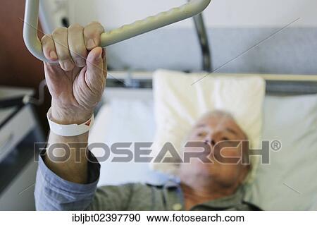 "Elderly man in a hospital, hand holding a hand grip in a hospital bed" View Large Photo Image Stock Image - "Elderly man in a hospital, hand holding a hand grip in a hospital bed". Fotosearch
