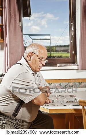 Stock Photo - Elderly man reading a newspaper. Fotosearch