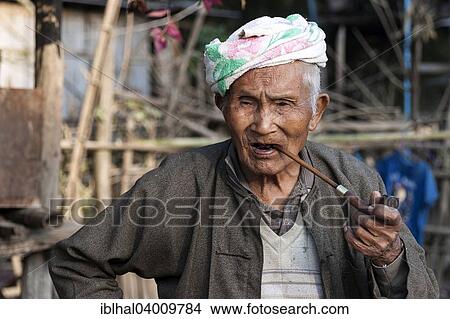 Picture - "Elderly man smoking a pipe, near Kyaing Tong, Myanmar, Asia". Fotosearch
