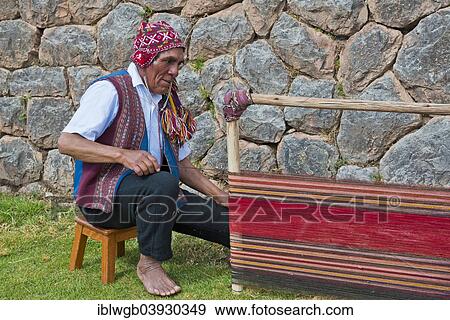Stock Photo - "Elderly man wearing a cap, Quechua Indian in traditional dress, sitting on the floor working on the stretcher of a loom, Cinchero, Urubamba Valley, Peru, South America". Fotosearch