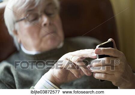 Elderly man working on his smartphone View Large Photo Image Stock Photo - Elderly man working on his smartphone. Fotosearch