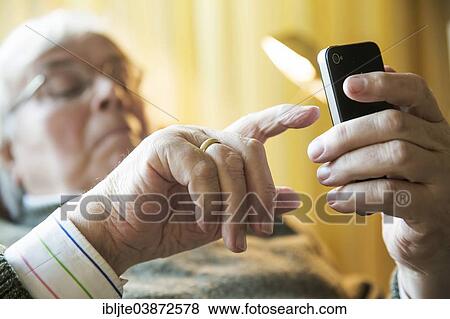 Elderly man working on his smartphone View Large Photo Image Stock Photo - Elderly man working on his smartphone. Fotosearch