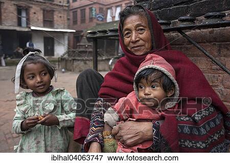 Stock Photo - "Elderly Nepalese woman with two children, Bhaktapur, Nepal, Asia". Fotosearch
