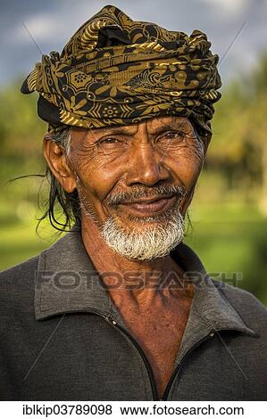 Stock Photo - "Elderly rice farmer wearing a head scarf, Ubud district, Bali, Indonesia, Asia". Fotosearch