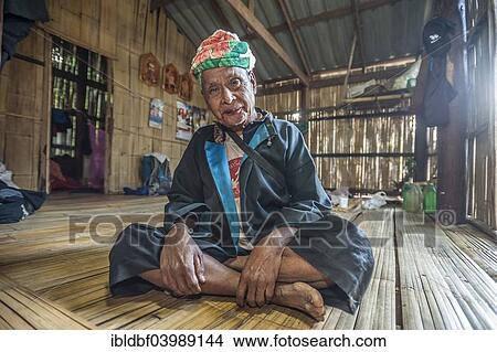 Picture - "Elderly smiling man from the Lahu people, hill tribe, ethnic minority, sitting on a veranda, Mae Hong Song Province, Northern Thailand, Thailand, Asia". Fotosearch