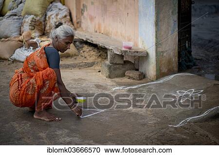 "Elderly woman creating a traditional Rangoli, Kolam or Muggu, decorative pattern made of coloured sand, outside a door, Rameswaram, Pamban Island, Tamil Nadu, India, Asia" View Large Photo Image Stock Image - "Elderly woman creating a traditional Rangoli, Kolam or Muggu, decorative pattern made of coloured sand, outside a door, Rameswaram, Pamban Island, Tamil Nadu, India, Asia". Fotosearch