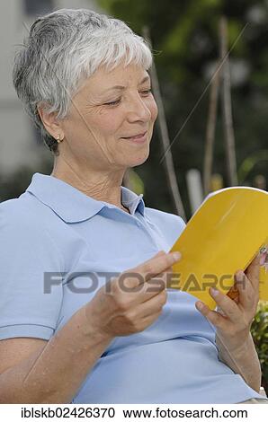 "Elderly woman, gray-haired, 55-65, reading a book outdoors" View Large Photo Image Stock Image - "Elderly woman, gray-haired, 55-65, reading a book outdoors". Fotosearch
