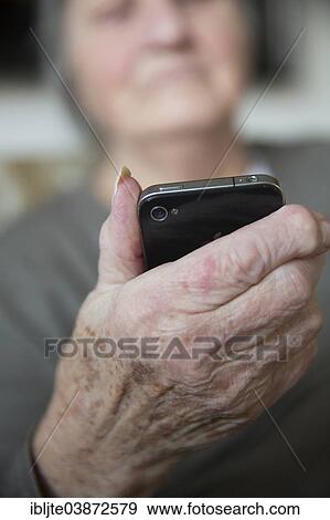 Elderly woman holding a smartphone View Large Photo Image Stock Photo - Elderly woman holding a smartphone. Fotosearch