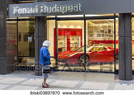 "Elderly woman standing in front of the shop window of a Ferrari dealer, Budapest, Hungary, Europe" View Large Photo Image Stock Image - "Elderly woman standing in front of the shop window of a Ferrari dealer, Budapest, Hungary, Europe". Fotosearch