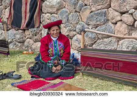 Picture - "Elderly woman wearing a hat, Quechua Indian in traditional dress, sitting on the floor in front of the stretcher of a loom, Cinchero, Urubamba Valley, Peru, South America". Fotosearch
