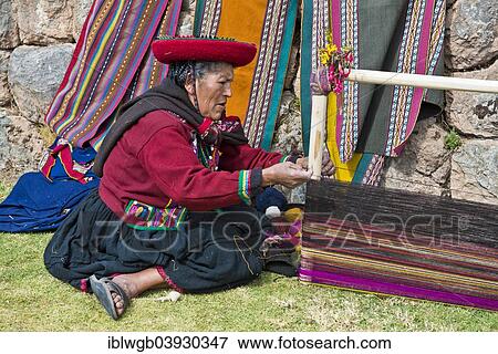 Stock Photo - "Elderly woman wearing a hat, Quechua Indian in traditional dress, sitting on the floor working on the stretcher of a loom, Cinchero, Urubamba Valley, Peru, South America". Fotosearch