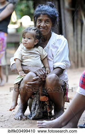 "Elderly woman with a child on her lap, in the community of Mbya-Guarani Indians, Campito, Caaguazu Department, Paraguay, South America" View Large Photo Image Stock Image - "Elderly woman with a child on her lap, in the community of Mbya-Guarani Indians, Campito, Caaguazu Department, Paraguay, South America". Fotosearch