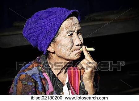 "Elderly woman with thanaka paste on her face wearing a hat and smoking a cigar, Myanmar, Burma, Southeast Asia, Asia" View Large Photo Image Stock Image - "Elderly woman with thanaka paste on her face wearing a hat and smoking a cigar, Myanmar, Burma, Southeast Asia, Asia". Fotosearch
