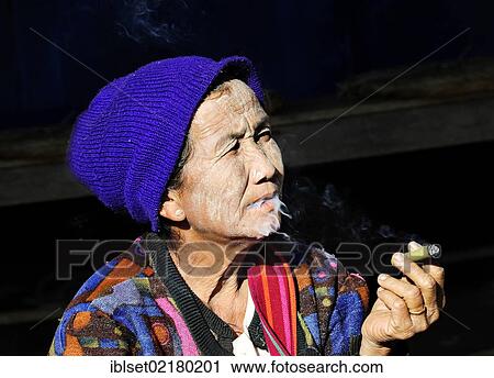 "Elderly woman with thanaka paste on her face wearing a hat and smoking a cigar, Myanmar, Burma, Southeast Asia, Asia" View Large Photo Image Stock Image - "Elderly woman with thanaka paste on her face wearing a hat and smoking a cigar, Myanmar, Burma, Southeast Asia, Asia". Fotosearch