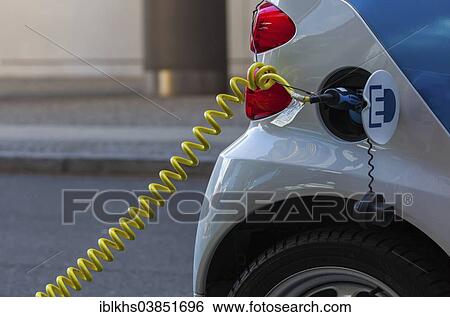 Stock Photograph - "Electric car being charged at a public charging station, Berlin, Germany, Europe". Fotosearch