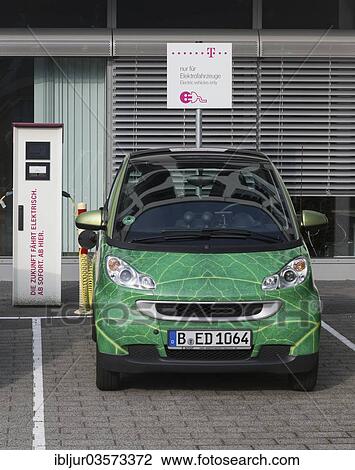 Stock Image - "Electric car being charged in a charging socket at the front of the Telekom-Zentrale headquarters, Bonn, North Rhine-Westphalia, Germany, Europe". Fotosearch