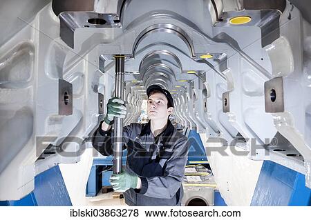"Employee fitting a tension rod into the engine frame of a marine engine, MAN Diesel and Turbo SE, Augsburg, Bavaria, Germany, Europe" View Large Photo Image Stock Photo - "Employee fitting a tension rod into the engine frame of a marine engine, MAN Diesel and Turbo SE, Augsburg, Bavaria, Germany, Europe". Fotosearch