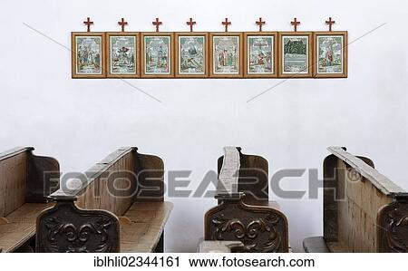 Stock Image - "Empty church pews, images depicting the Stations of the Cross number 8 to 15 at the back, Church of St. George, Ruhpolding, Chiemgau, Upper Bavaria, Bavaria, Germany, Europe". Fotosearch