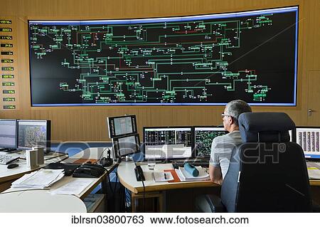 Stock Image - "Engineer sitting at his work station in the Transmission Control Center, TCC, of transmission network operator 50Hertz, Neuenhagen, Brandenburg, Germany, Europe". Fotosearch