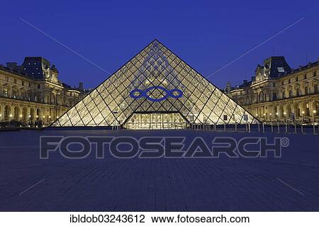 Stock Image - "Entrance pyramid by architect I. M. Pei, Musee du Louvre, Louvre Museum, with a logo advertising an exhibition by Michelangelo Pistoletti, Paris, Ile-de-France, France, Europe". Fotosearch