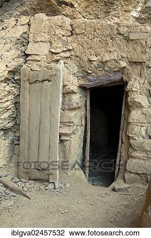 "Entrance with a carved wooden door to? Çï? Çïa stone hut at the abandoned settlement of Sap Bani Khamis under a ledge in the Grand Canyon of Oman in the Wadi at Nakhar, Jabal Akhdar Mountains, Sultanate of Oman, Middle East" View Large Photo Image Stock Image - "Entrance with a carved wooden door to? Çï? Çïa stone hut at the abandoned settlement of Sap Bani Khamis under a ledge in the Grand Canyon of Oman in the Wadi at Nakhar, Jabal Akhdar Mountains, Sultanate of Oman, Middle East". Fotosearch