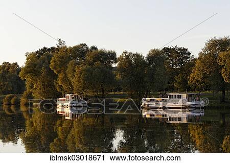 Stock Image - "Evening, houseboats on the Saone, a quiet tributary, in the harbour of Marian Saone Valley, Traves, Vesoul, Region Franche-Comte, Dep. Haute-Saone, France, Europe". Fotosearch
