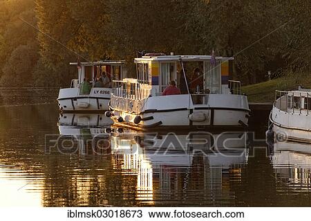 Stock Image - "Evening, houseboats on the Saone, a quiet tributary, in the harbour of Marian Saone Valley, Traves, Vesoul, Region Franche-Comte, Dep. Haute-Saone, France, Europe". Fotosearch