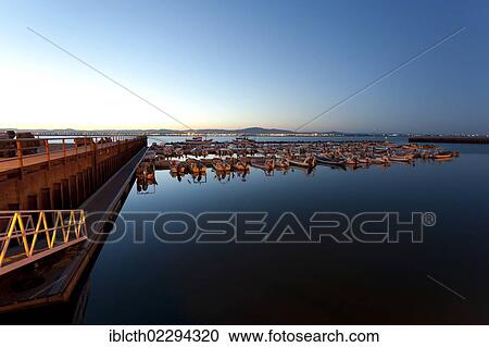 Stock Image - "Evening mood in the harbour with water as smooth as a mirror, Culatra, Algarve, Portugal, Europe". Fotosearch