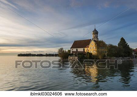"Evening mood with the Baroque Church of St. George on the banks of Wasserburg am Bodensee, Lake Constance, Wasserburg - Bodensee, Swabia, Bavaria, Germany, Europe" View Large Photo Image Stock Photograph - "Evening mood with the Baroque Church of St. George on the banks of Wasserburg am Bodensee, Lake Constance, Wasserburg - Bodensee, Swabia, Bavaria, Germany, Europe". Fotosearch